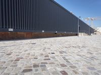 a brick building with glass windows and sidewalk leading to it and a black fire hydrant