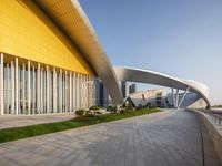 an outside view of an modern looking building, in yellow tones and white railings