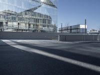 a large glass building in the background with other buildings behind it in the foreground