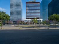 an empty street in front of a building and trees on the other side of the road