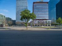 an empty street in front of a building and trees on the other side of the road