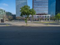 an empty street in front of a building and trees on the other side of the road