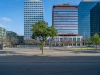 an empty street in front of a building and trees on the other side of the road