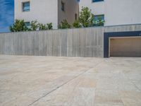 the gray concrete walls of a building have a line of steps on the left side