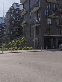 a small boy is skateboarding in an empty area of a city street near tall buildings