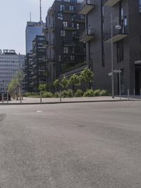 a small boy is skateboarding in an empty area of a city street near tall buildings