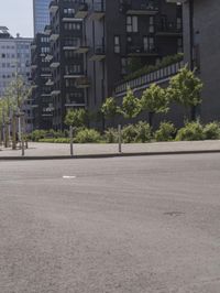 a small boy is skateboarding in an empty area of a city street near tall buildings