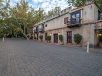 the courtyard of a small old country town house in the afternoon with the sky in the background