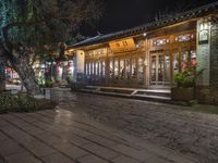 there is a street that leads to a small restaurant at night with smoke swirling around