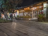 there is a street that leads to a small restaurant at night with smoke swirling around