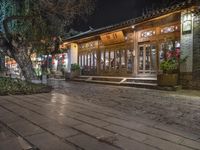 there is a street that leads to a small restaurant at night with smoke swirling around