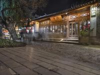 there is a street that leads to a small restaurant at night with smoke swirling around