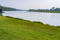 a small tv is sitting on a small hill near the water and grass is growing