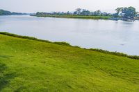 a small tv is sitting on a small hill near the water and grass is growing