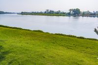 a small tv is sitting on a small hill near the water and grass is growing