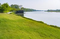 a small tv is sitting on a small hill near the water and grass is growing