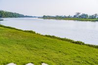 a small tv is sitting on a small hill near the water and grass is growing