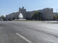 a small water fountain spews out over a city street and traffic lights in the background