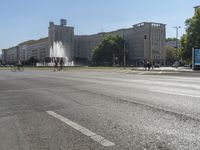 a small water fountain spews out over a city street and traffic lights in the background