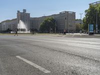 a small water fountain spews out over a city street and traffic lights in the background