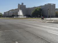 a small water fountain spews out over a city street and traffic lights in the background