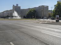 a small water fountain spews out over a city street and traffic lights in the background