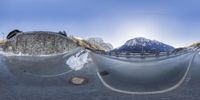 fish eye view of snow capped landscape and trees in the foreground of a mountain area