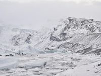a large glacier with many melting pieces on it's surface, including small mountains
