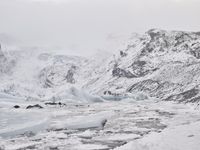 a large glacier with many melting pieces on it's surface, including small mountains