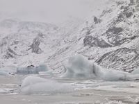 a large glacier with many melting pieces on it's surface, including small mountains