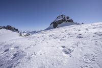 a person skiing on a mountain with some snow on them on a clear day at the top