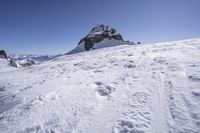 a person skiing on a mountain with some snow on them on a clear day at the top