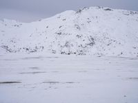 a couple snowboards is laying in the snow on a road in front of mountains