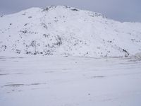 a couple snowboards is laying in the snow on a road in front of mountains