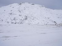 a couple snowboards is laying in the snow on a road in front of mountains