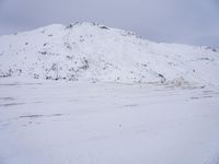 a couple snowboards is laying in the snow on a road in front of mountains