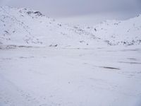 a couple snowboards is laying in the snow on a road in front of mountains