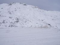 a couple snowboards is laying in the snow on a road in front of mountains