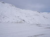 a couple snowboards is laying in the snow on a road in front of mountains