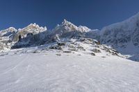 a person on skis is sitting near snow on the ground with mountains in the background