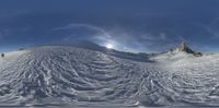 a snow covered mountain under a blue sky with clouds over the top of it,