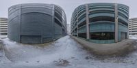 two buildings side by side in the snow and one is half built up to look like a spiral stair