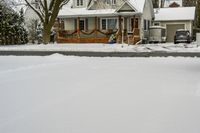 a driveway that has snow all over it and trees in the yard that is on both side of house