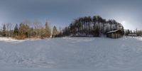 there is a snow covered field with tracks in the snow under a tree line and a sky