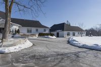 an empty house has no roof on a clear winter day with snow piled up all around