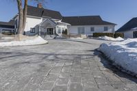 an empty house has no roof on a clear winter day with snow piled up all around