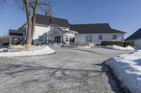 an empty house has no roof on a clear winter day with snow piled up all around