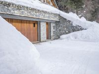 a house with a garage covered in snow in front of the house with two doors