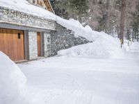 a house with a garage covered in snow in front of the house with two doors
