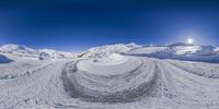 a panorama view of an almost empty ski area in the day time with a blue sky